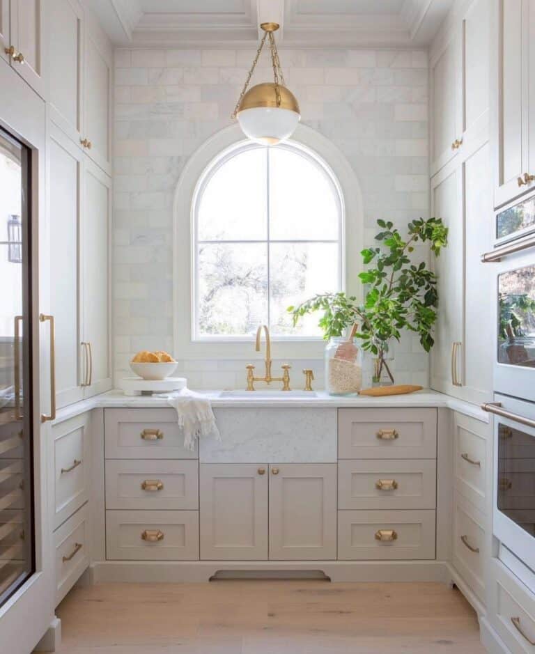Arched Kitchen Window With Brass Accents