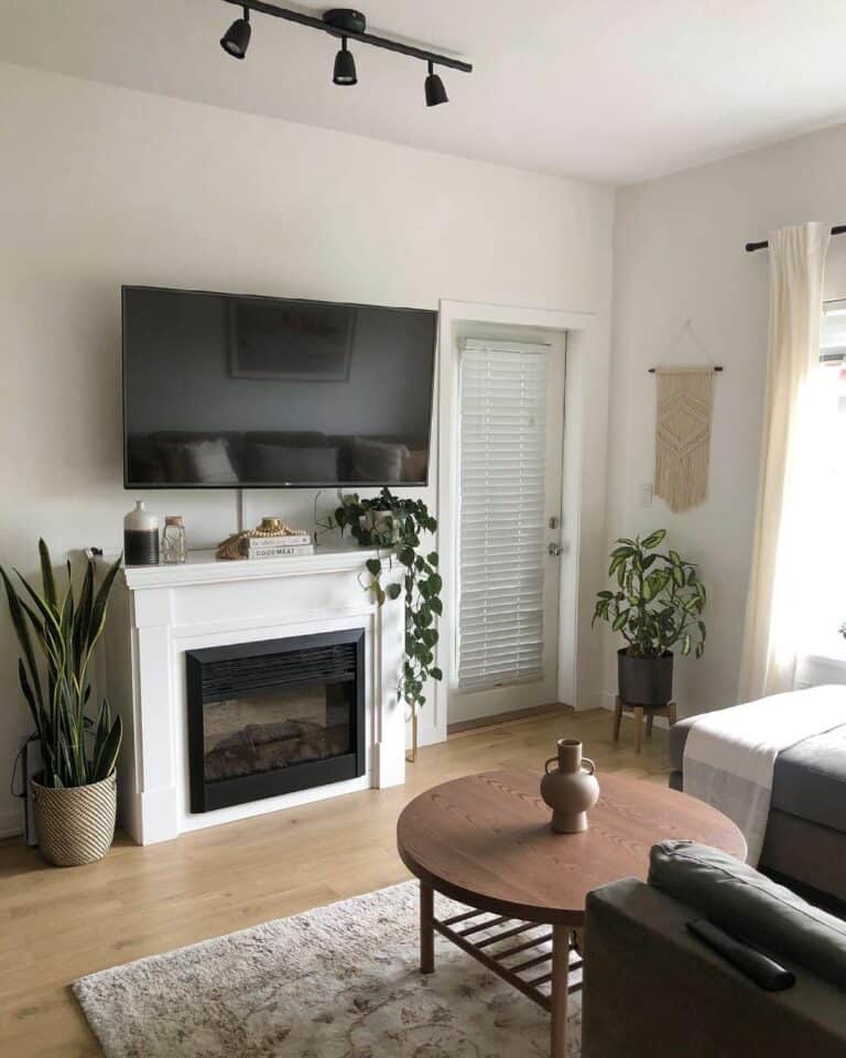 Living Room With TV Above White Fireplace