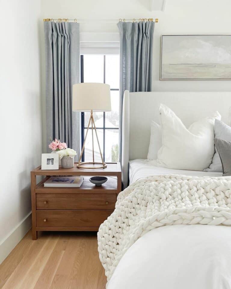Large Gold Lamp and Pink Flowers on a Wooden Nightstand