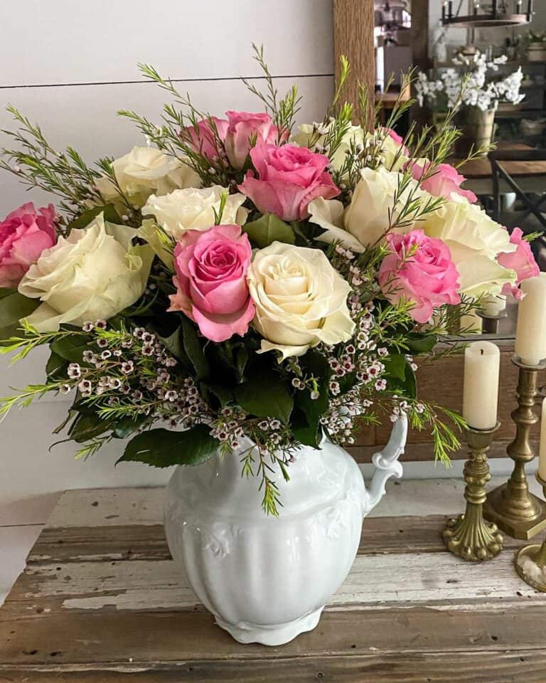 White Pitcher With Colorful Flowers on Rustic Table