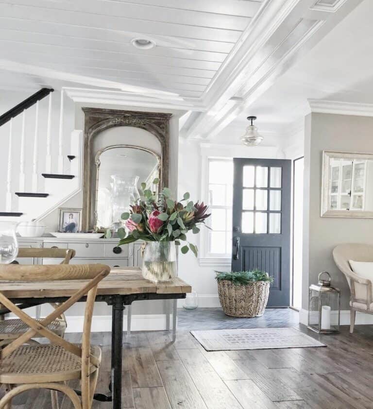 Entryway with a Sculpted White Baseboard and a Deep Wood Floor